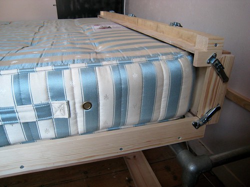 Head end of the wallbed folded up and latched round the mattress