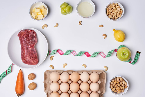 Fresh keto food and measuring tape on white background. Top view