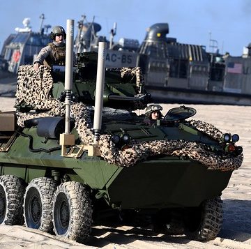 Marines unload assault reconnaissance vehicles from a landing craft.