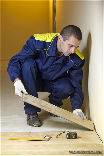 Carpenter putting wood floor boards. Home construction