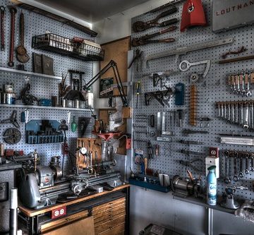 Machine room wall with lathe, tooling and metal chop-saw.