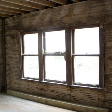 Walls stripped down to wood lathe, dining room windows before restoration