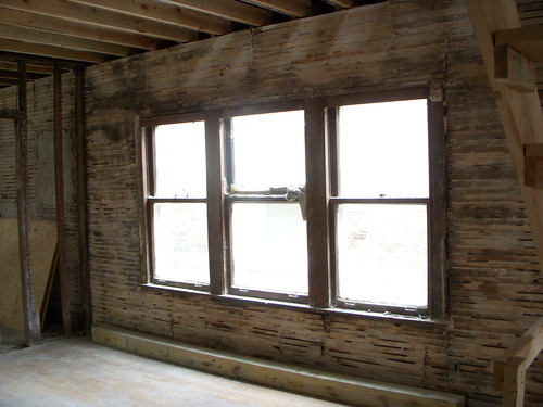 Walls stripped down to wood lathe, dining room windows before restoration